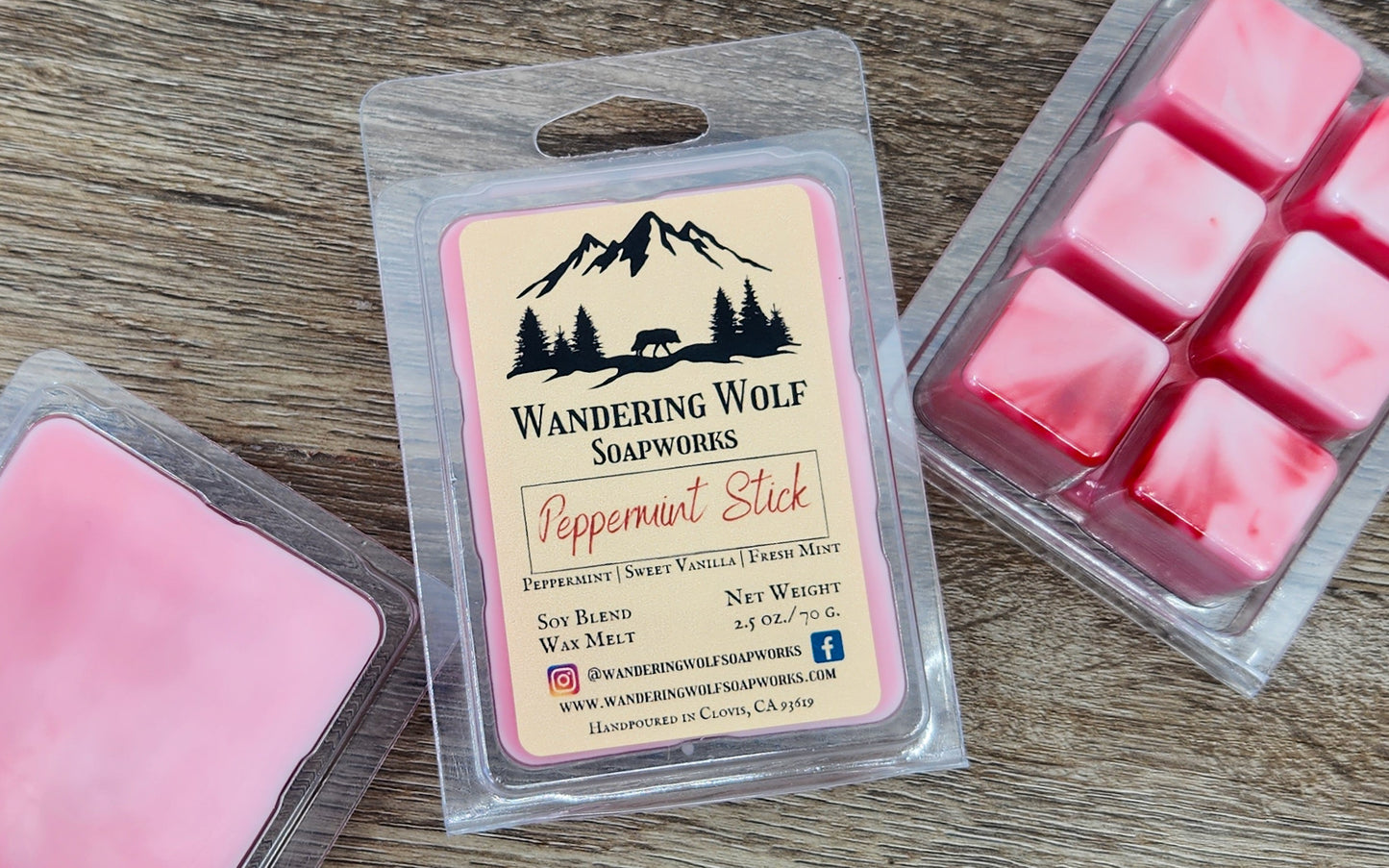 Packaging of peppermint stick wax melts with visible wax cubes outside the package, with a label that reads 'Wandering Wolf Soapworks - Peppermint Stick'. The background is a wooden surface.