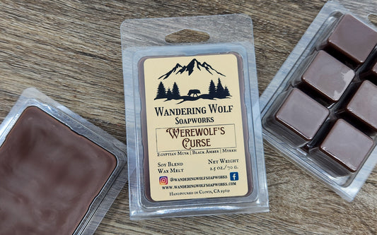 A package of Wandering Wolf Soapworks Werewolf's Curse wax melts, with visible brown wax cubes and a label describing the scent and product information.