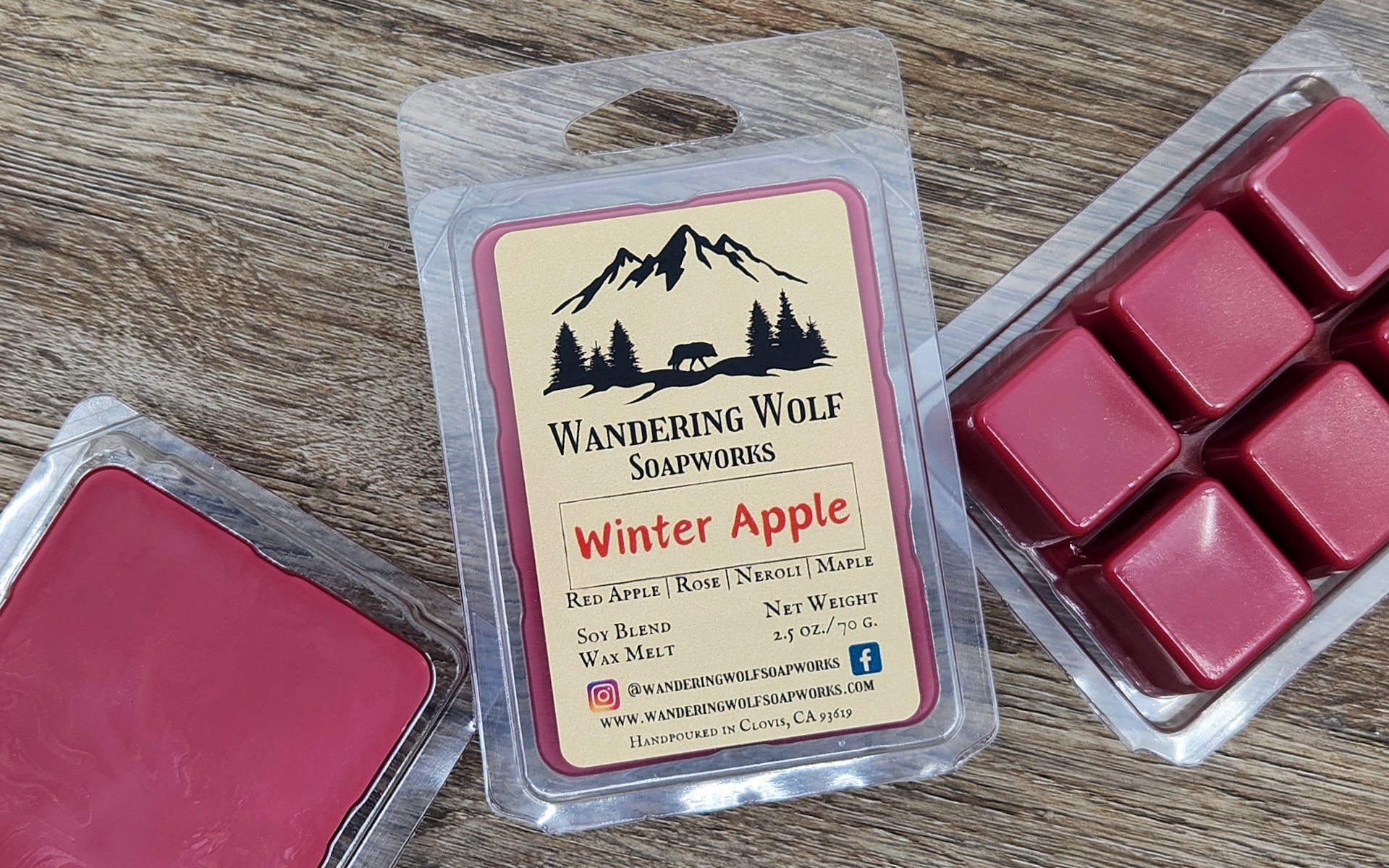 Wax melts in a 'Winter Apple' packaging by Wandering Wolf Soapworks on a wooden surface.